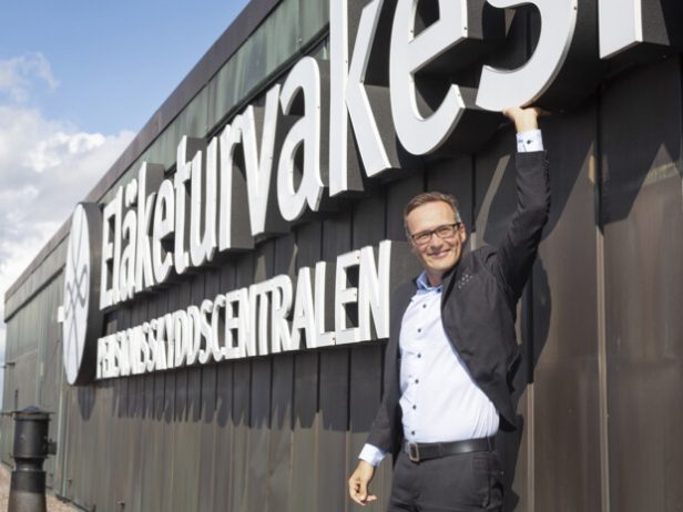 Kesäkuun alussa Eläketurvakeskuksen toimitusjohtajana aloittanut Mikko Kautto kurottaa kätensä ylös kohti Eläketurvakeskuksen liikemerkkiä ETK:n toimitalon katolla.