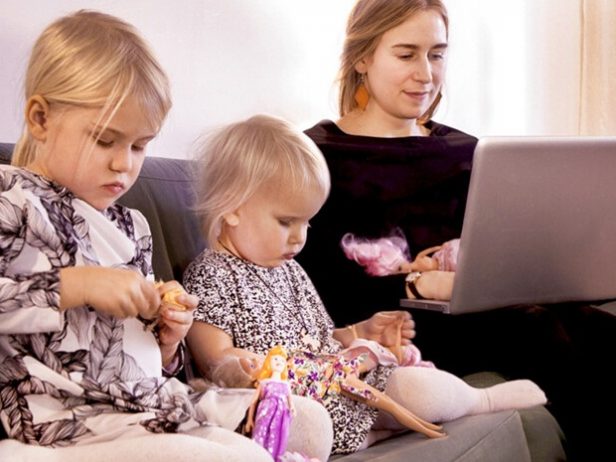 Mamma och två barn sitter i soffan.